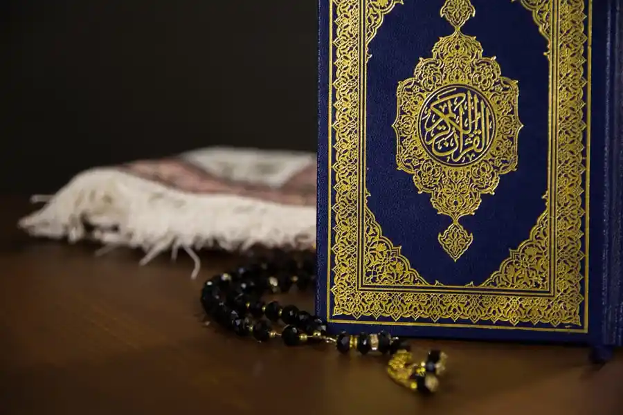 Blue and gold Quran with prayer beads for Islamic studies